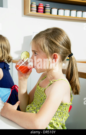 Mädchen trinken Soda In der Küche Stockfoto