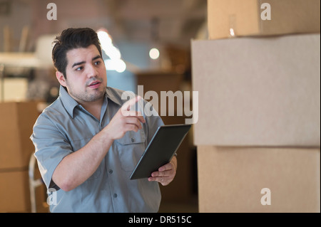 Gemischte Rassen Arbeitnehmer zählen Kisten im Lager Stockfoto