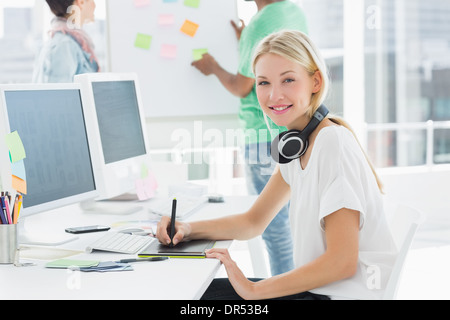 Künstler Zeichnung etwas auf Grafiktablett mit Kollegen hinter Stockfoto