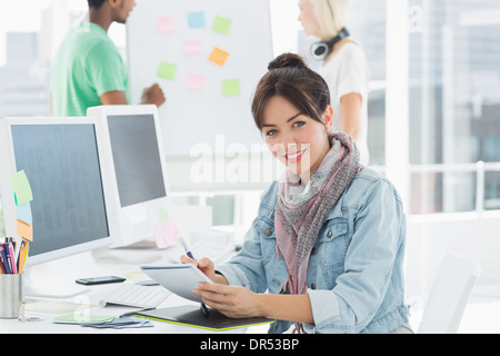 Künstler Zeichnung etwas auf Grafiktablett mit Kollegen hinter Stockfoto