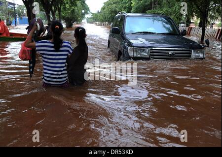 Jakarta, Indonesien. 20. Januar 2014. Bewohner waten durch Flutwasser, während ein Auto in Nord-Jakarta, Indonesien, 20. Januar 2014 passiert. Weit verbreitete Flut leidet der indonesischen Hauptstadt Jakarta hat acht Menschen getötet und gezwungen mehr als 60.000 anderen Gewässern ab Montag zu entkommen als heftigen Regenfälle halten Beziehungsmomente Stadt, offizielle sagte. Bildnachweis: Veri Sanovri/Xinhua/Alamy Live-Nachrichten Stockfoto