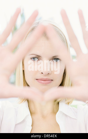 Woman framing her face with hands Stockfoto