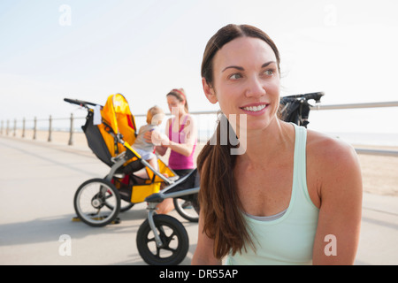 Kaukasischen Müttern mit Kinderwagen auf der Strandpromenade Stockfoto