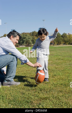 Hispanische Vater und Sohn Fußballspielen im freien Stockfoto