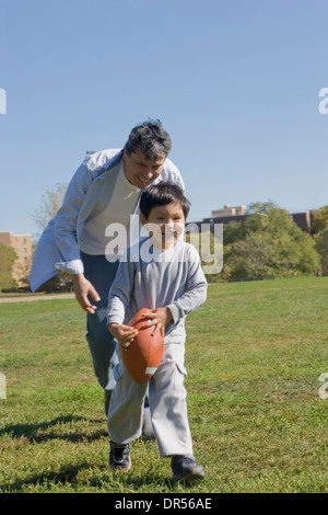 Hispanische Vater und Sohn Fußballspielen im freien Stockfoto