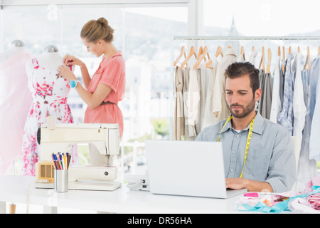 Mann mit Laptop mit Modedesigner arbeiten im studio Stockfoto