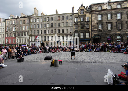 Eine große Menschenmenge versammelt, um ein Straßenkünstler auf der Royal Mile Edinburgh zu sehen Stockfoto