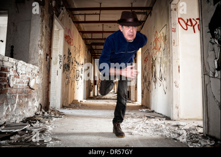 Mann läuft Weg in verlassenen Gebäude Stockfoto