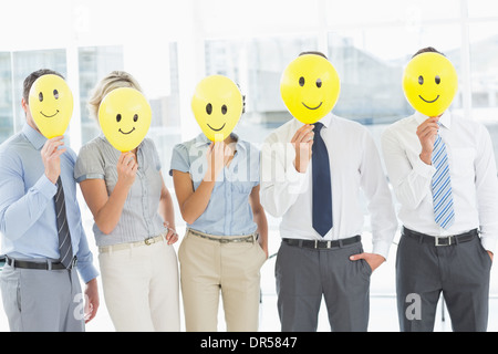 Business-Leute mit glücklichen Lächeln vor Gesichtern Stockfoto