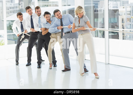 Gruppe von Geschäftsleuten ziehen Seil im Büro Stockfoto