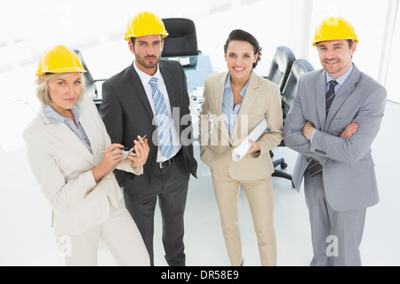 Zuversichtlich Architekten mit harte Hüte und Blaupause im Büro Stockfoto