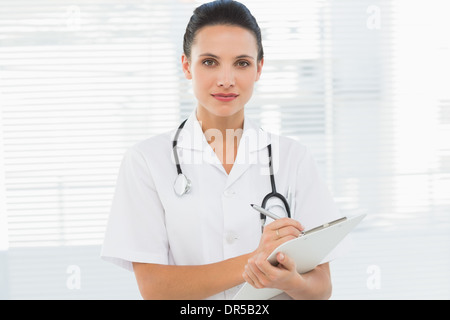 Schöne junge Ärztin mit Zwischenablage Stockfoto