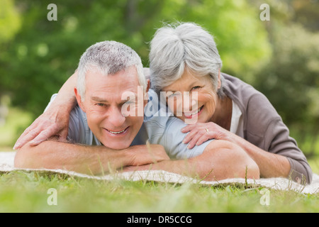 Lächelnde entspannte älteres Paar im Park liegen Stockfoto