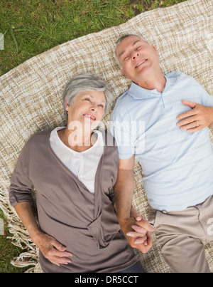 Lächelnde entspannte älteres Paar im Park liegen Stockfoto