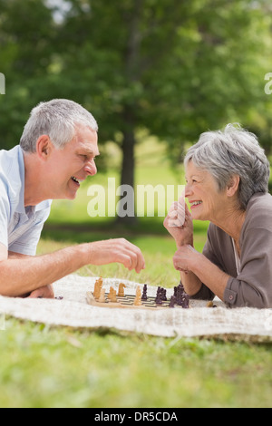 Gerne älteres Paar beim Schachspiel im park Stockfoto