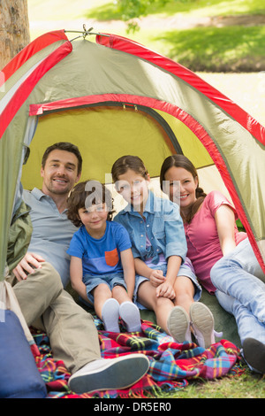 Paar mit Kinder sitzen im Zelt im park Stockfoto