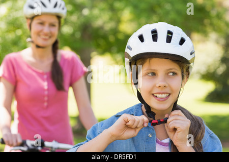 Lächelnde Frau mit ihrer Tochter mit dem Fahrrad Stockfoto