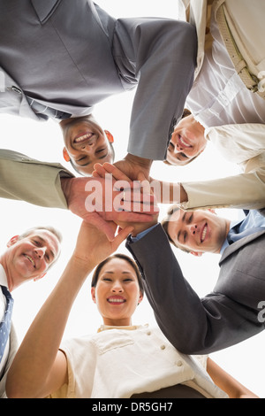 Blickte auf die Kamera in Händen zusammen glücklich Business-team Stockfoto