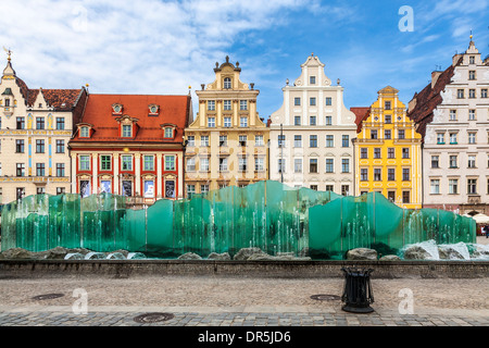 Der moderne Brunnen vor dem Hintergrund der mittelalterlichen und barocken Häuser in der Breslauer Altstadt Marktplatz oder Rynek. Stockfoto