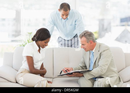 Verkäufer-Client zeigt, wo die Papiere unterschreiben Stockfoto