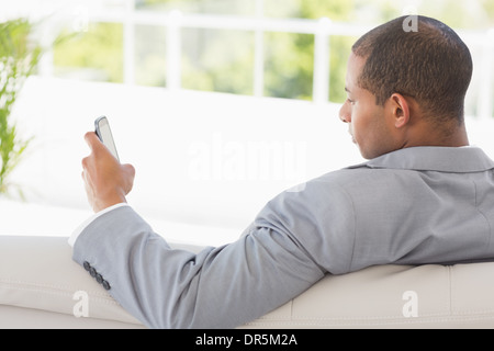Geschäftsmann, die Lektüre eines Textes auf der couch Stockfoto