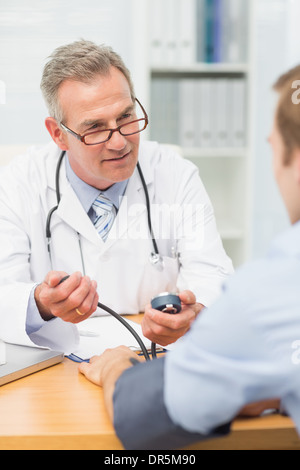 Lächelnd Reife Arzt seine Patienten der Blutdruck Einnahme Stockfoto