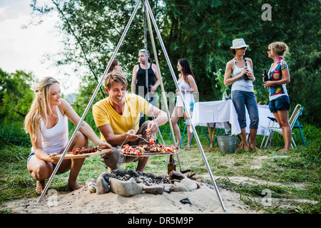 Freunden Grillen am Riverside, Ausläufer der Alpen, Bayern, Deutschland Stockfoto