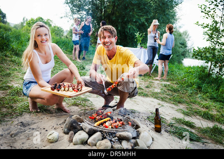 Freunden Grillen am Riverside, Ausläufer der Alpen, Bayern, Deutschland Stockfoto