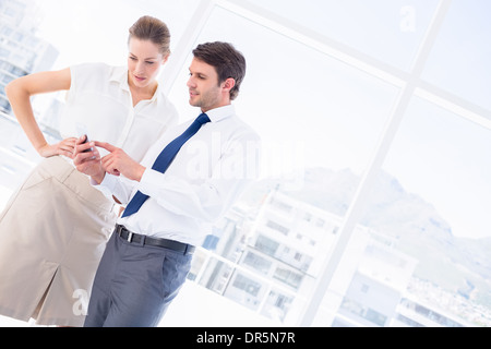 Elegant gekleidet Kollegen Blick auf Handy Stockfoto
