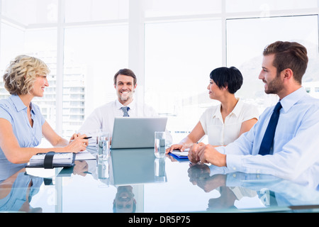 Führungskräfte, die herumsitzen und Konferenztisch Stockfoto