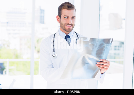 Porträt eines lächelnden jungen männlichen Arztes Untersuchung Röntgen Stockfoto