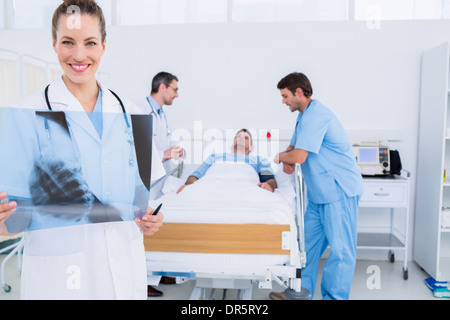 Arzt Holding Röntgen mit Chirurgen und Patienten im Krankenhaus Stockfoto