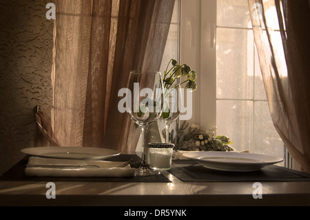 paar Weingläser auf dem Tisch vor einem Fenster und in einer weißen Vase, sonnigen Tag Innenaufnahme Stockfoto