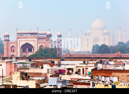 Wohnviertel in Agra mit großen Tor (Darwaza-i Rauza) und Taj Mahal als Kulisse Stockfoto