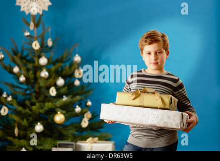 Kleiner Junge hält Weihnachtsgeschenke, München, Bayern, Deutschland Stockfoto