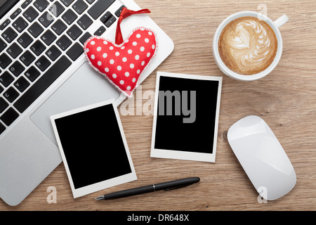 Valentinstag leere Bilderrahmen und Spielzeug Herz über Büroarbeitsplatz Stockfoto