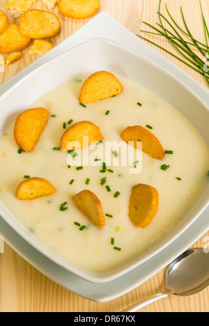 Blumenkohl Sahne mit Crackern und Schnittlauch in einer Schüssel auf einem Holztisch Stockfoto