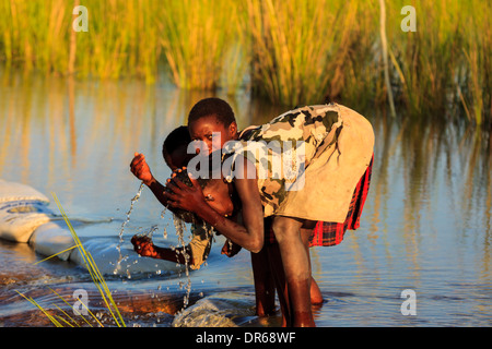 Kinder planschen im kühlen Wasser Abkühlung im Fluss Okavango Botswana Afrika Stockfoto