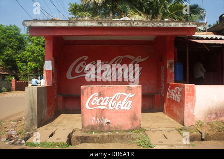 Der Einfluss von Coca-Cola erstreckt sich an einer Bushaltestelle in einem Goan Dorf Stockfoto