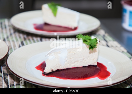 Käsekuchen mit Sahne in Obstkonfitüre Stockfoto