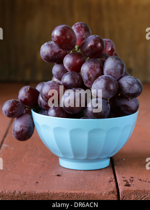 große Reifen schwarzen Trauben in einer blauen Schüssel Stockfoto
