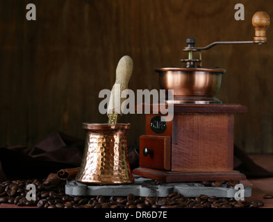 Kupfer-Kaffeekanne mit Bohnen auf einem Holztisch Stockfoto