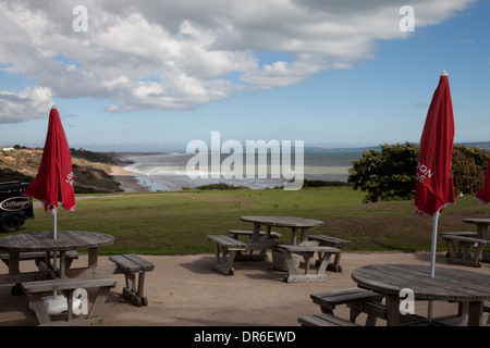 Tischen und Sonnenschirmen an der Cliffhanger-Café, zuvorkommend-sur-mer, Dorset Stockfoto