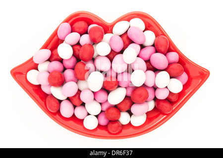 Lippen Sie-geformte Schale voll von Candy-beschichtete Pralinen isoliert auf weiss Stockfoto