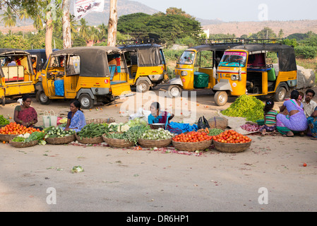 Indische Frauen verkaufen Gemüse aus Körben auf einem Straßenmarkt in Puttaparthi, Andhra Pradesh, Indien Stockfoto