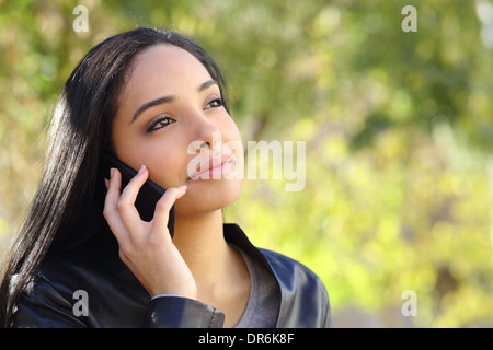 Arab Business-Frau auf dem Handy in einem Park mit einem grünen Hintergrund Stockfoto