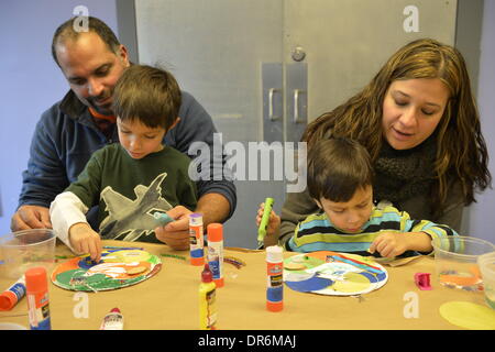 Garden City, New York, USA 20. Januar 2014. L-R, JESSE RIVERA; Sohn JADEN RIVERA, 4; Frau ALEXANDRA RIVERA; und Sohn JACOB RIVERA, 5 der Sea Cliff, schaffen Kunstwerke des Friedens am Programm Dreaming mit Dr. Martin Luther King, Jr. wo Kinder auch Dr. King Leben auf Long Island Kindermuseum erforscht, um den offiziellen bundesweiten Feiertag Geburtstag von Martin Luther King, Jr. zu feiern. Stockfoto