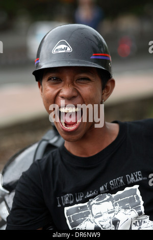 Lächelnd indonesischen Jungen College-Student schwarzes T-shirt und schwarze Helm tragen. Kupang, West-Timor, Indonesien. Nov 2005 Stockfoto
