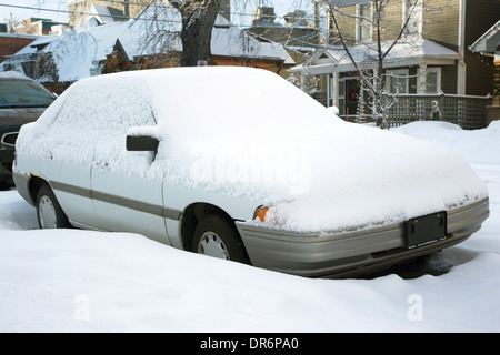 Auto in Neuschnee auf Wohnstraße bedeckt Stockfoto