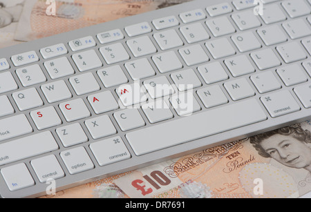 Computer-Tastatur mit Buchstaben des Arbeit Betrugs auf einem Haufen von zehn Pfund-Noten Stockfoto